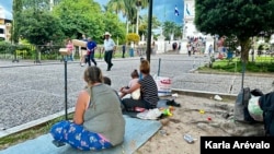 Mayeisy y sus hijos descansan en los jardines del templo de Esquipulas, el primer pueblo de Guatemala que se encuentra tras cruzar la frontera con Honduras. [Fotografía Karla Arévalo / VOA]