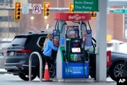 Seorang perempuan mengisi bahan bakar di GetGo Mini Mart di Valencia, Pa., 23 Januari 2023. (AP/Gene J. Puskar)