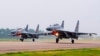 FILE - In this undated photo released by China's Xinhua news agency, two Chinese SU-30 fighter jets take off from an unspecified location to fly a patrol over the South China Sea.