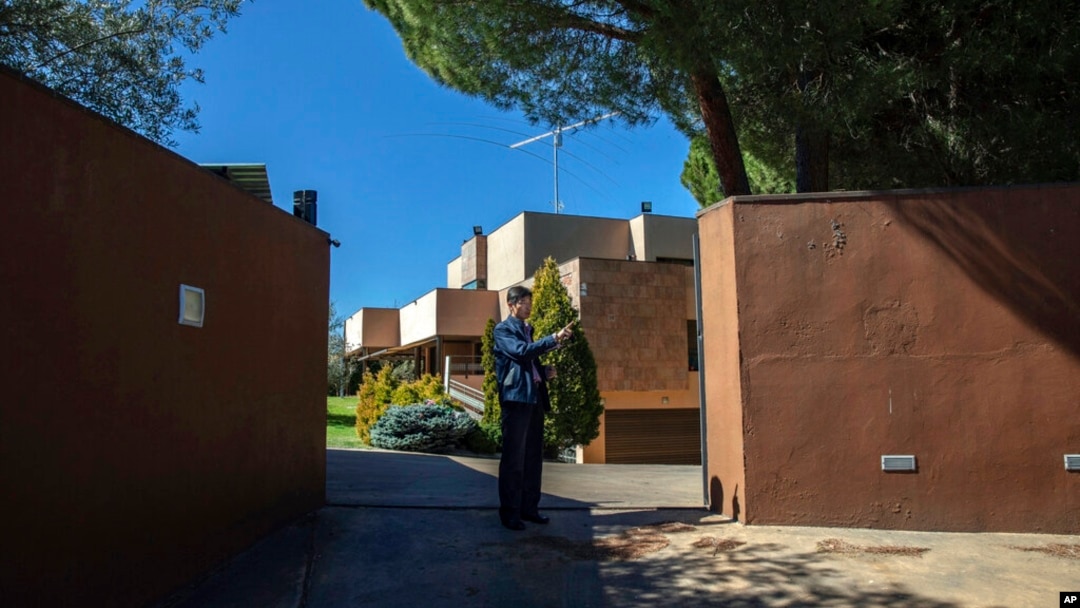 FILE - A member of North Korea's embassy stands guard outside the diplomatic building in Madrid, Spain, March 13, 2019. North Korea will shutter its embassies in Uganda, Angola and Spain, as well as its consulate in Hong Kong. 