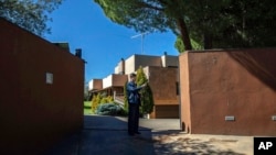 FILE - A member of North Korea's embassy stands guard outside the diplomatic building in Madrid, Spain, March 13, 2019. North Korea will shutter its embassies in Uganda, Angola and Spain, as well as its consulate in Hong Kong. 