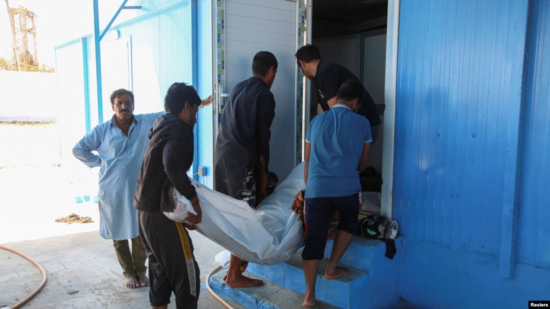People carry the body of a migrant, whose boat sank in the sea, after the Libyan Coast Guards took them out from the Mediterranean Sea, in Garaboli, Libya, April 25, 2023. 
