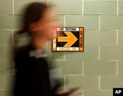 FILE- A student leaves after taking the SAT at Upper Arlington High School in Upper Arlington, Ohio. (AP Photo/Paul Vernon, File)