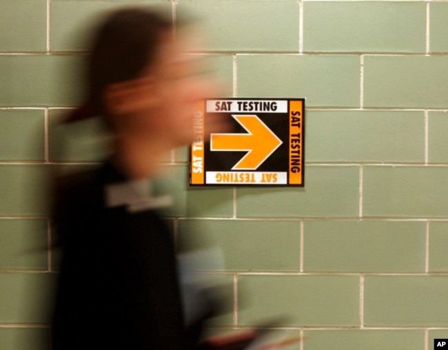 FILE- A student leaves after taking the SAT at Upper Arlington High School in Upper Arlington, Ohio. (AP Photo/Paul Vernon, File)