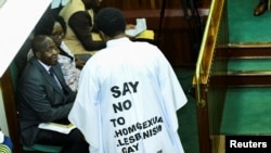 FILE - Member of Parliament from Bubulo contituency John Musira, dressed in an anti-gay gown, attends the debate of the Anti-Homosexuality Act inside the chambers at the Parliament buildings in Kampala, Uganda, March 21, 2023. 