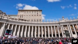 People gather as Pope Francis recites the Regina Coeli noon prayer from the window of his studio overlooking St.Peter's Square, at the Vatican, Apr. 16, 2023.