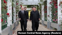 Ruski predsjednik Vladimir Putin i sjevernokorejski lider Kim Jong Utokom šetnje vrtom pansiona Kumsusan u Pjongjangu, Sjeverna Koreja, na ovoj slici koju je objavila Korejska centralna novinska agencija 20. juna 2024. (KCNA preko Reutersa)