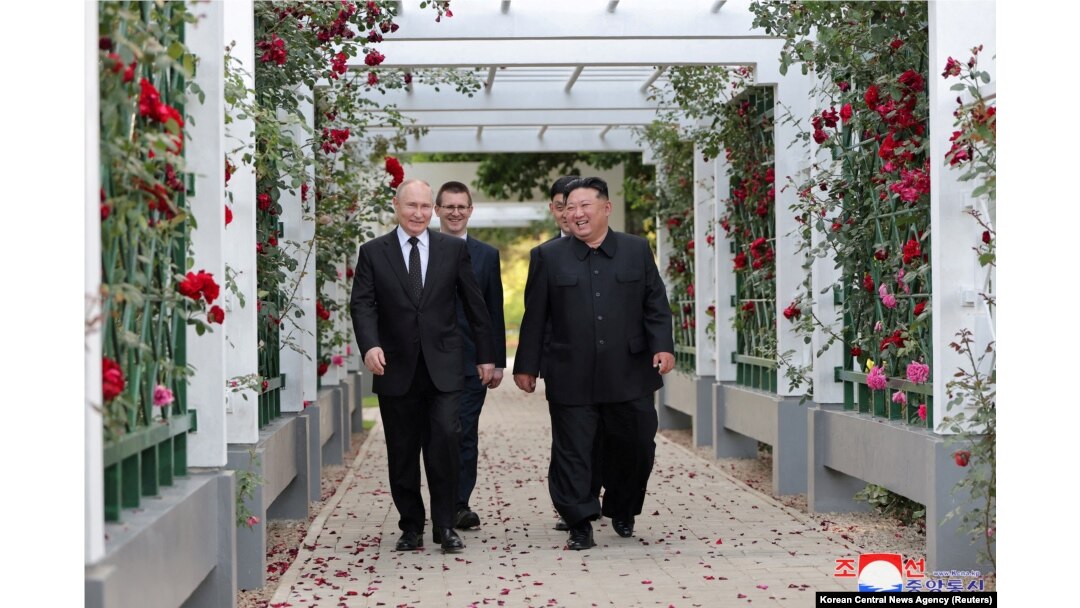 Presiden Rusia Vladimir Putin dan pemimpin Korea Utara Kim Jong Un bereaksi saat berjalan-jalan di taman Wisma Kumsusan di Pyongyang, Korea Utara, 20 Juni 2024. (KCNA via Reuters)