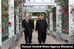 Presiden Rusia Vladimir Putin dan pemimpin Korea Utara Kim Jong Un bereaksi saat berjalan-jalan di taman Wisma Kumsusan di Pyongyang, Korea Utara, 20 Juni 2024. (KCNA via Reuters)