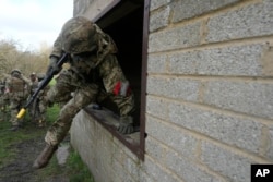 Under the guidance of British soldiers, Ukrainian recruits train at an army camp in South West England, Feb. 20, 2024. Britain's Defense Ministry announced it will spend $311 million over the next year to boost Ukraine's artillery ammunition.