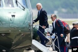 FILE - President Joe Biden boards Marine One with his son, Hunter Biden, as he leaves Andrews Air Force Base, Maryland, on his way to Camp David, June 24, 2023.