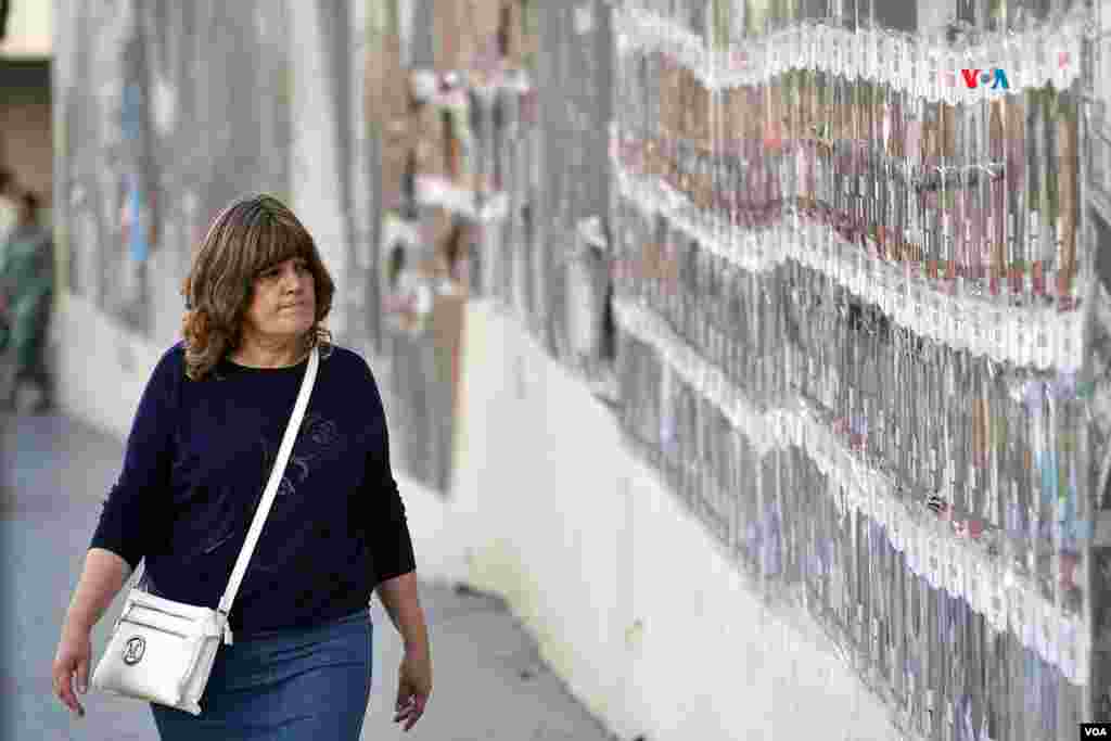 Una mujer observa los carteles con los rostros de los rehenes en poder de Hamás.