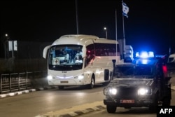 An Israeli border guard vehicle escorts a Red Cross bus to the Ofer military prison in the occupied West Bank, Nov. 30, 2023, amid preparations for the release of Palestinian prisoners in exchange for Israeli hostages held by Hamas in Gaza.
