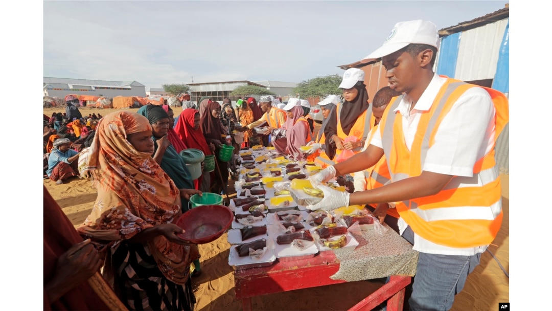 LSM setempat menyiapkan makanan berbuka puasa untuk warga di kamp pengungsi internal di pinggiran Mogadishu, Somalia, Jumat, 24 Maret. (AP/Farah Abdi Warsameh)