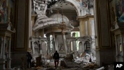 Church personnel inspect damage inside the Transfiguration Cathedral in Odesa, Ukraine, July 23, 2023, following Russian missile attacks.