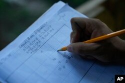 FILE - Seorang siswa mencatat lokasi artefak yang ditemukan di lokasi pemakaman Afrika di Kingston, NY, 5 Agustus 2024. (Seth Wenig/AP)