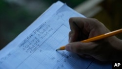 FILE - A student records the location of artifacts found while working at the site of an African burial ground in Kingston, NY, Aug. 5, 2024.