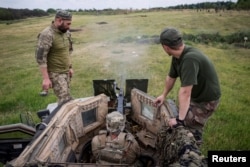 Miembros del servicio ucraniano se entrenan para disparar una ametralladora Browning M2 sobre un vehículo Oshkosh M-ATV protegido contra minas y emboscadas (MRAP) durante un ejercicio militar cerca de una línea del frente, en la región de Donetsk, el 12 de junio de 2024.