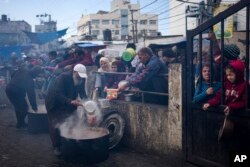 Warga Palestina antre untuk mendapatkan makanan gratis di Rafah, Jalur Gaza, Jumat, 16 Februari 2024. (Foto: AP)