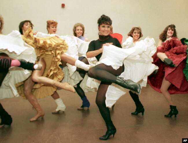 FILE - Broadway star Chita Rivera, foreground, and the Radio City Music Hall Rockettes rehearse Cole Porter's "Can Can" in New York on Jan. 21, 1988. (AP Photo/Marty Lederhandler, File)