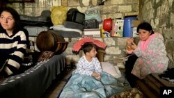 Anak-anak berada di tempat perlindungan selama penembakan di Stepanakert di Nagorno-Karabakh, Azerbaijan, Rabu, 20 September 2023. (AP/Siranush Sargsyan)