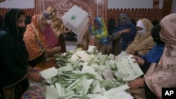 Members of polling staff count votes after the polls closed for parliamentary elections, in Peshawar, Pakistan, Feb. 8, 2024. 