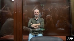 Igor Girkin (Strelkov), the former top military commander of the self-proclaimed Donetsk People's Republic and nationalist blogger, sits inside a glass defendants' cage during a hearing to consider a request on his pre-trial arrest in Moscow, July 21, 2023.
