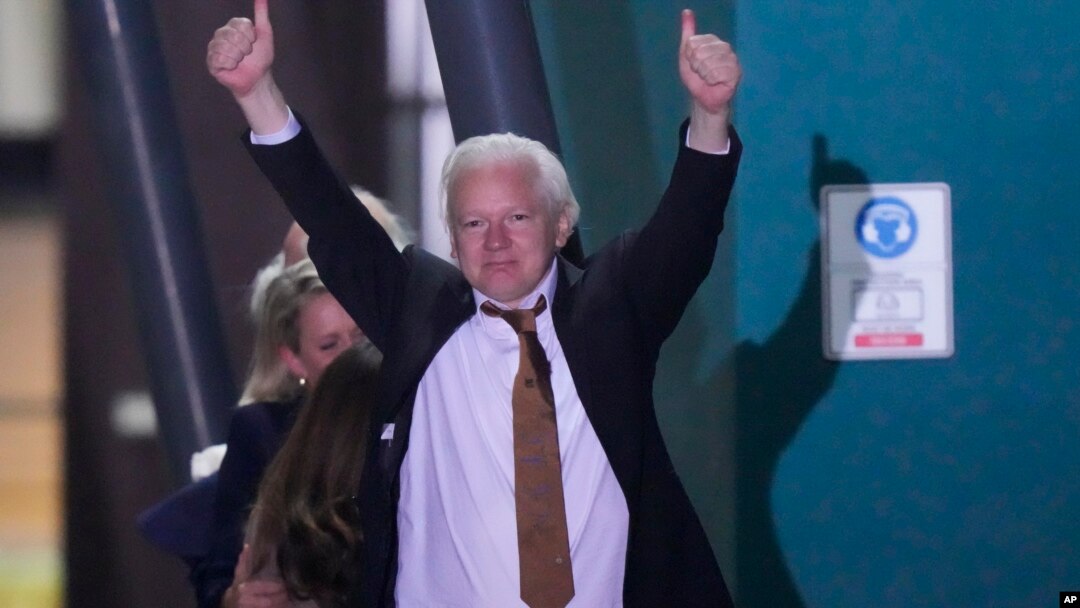 Pendiri WikiLeaks Julian Assange mengangkat kedua tangan, setelah mendarat sebagai orang bebas di pangkalan udara RAAF Fairbairn di Canberra, Australia, Rabu 26 Juni 2024.