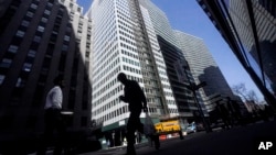 FILE - A pedestrian is silhouetted against a high rise at 160 Water Street in Manhattan's financial district, as the building is undergoing a conversion to residential apartments, Tuesday, April 11, 2023, in New York. (AP Photo/Bebeto Matthews)