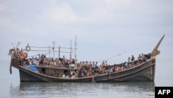 Pengungsi Rohingya yang baru tiba terdampar di perahu karena masyarakat sekitar memutuskan untuk tidak mengizinkan mereka mendarat setelah menyediakan air dan makanan di Pineung, Aceh pada 16 November 2023. (Foto: AFP)