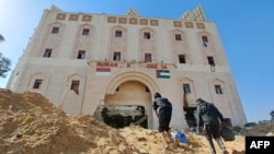 Orang-orang berjalan menuju Rumah Sakit Indonesia di pinggir kamp pengungsi Jabalia di Jalur Gaza utara, setelah pasukan Israel dilaporkan menggerebek fasilitas medis tersebut, 24 November 2023. (Mohammad AHMAD/AFP)