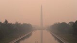With the Washington Monument in the background and a thick layer of smoke, Marine Corps honor color guard rehearse, June 8, 2023, in Washington.