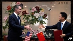 美国加州州长纽森(左)在北京访问期间与中国国家发改委主任郑栅洁签署备忘录。（2023年10月25日）