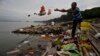 FILE - A Hindu devotee throws flowers and plastic bags into Brahmaputra river in Gauhati, India, Oct. 9, 2019. Negotiators at UNESCO in Paris discuss ways to end plastic pollution.