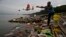 FILE - A Hindu devotee throws flowers and plastic bags into Brahmaputra river in Gauhati, India, Oct. 9, 2019. Negotiators at UNESCO in Paris discuss ways to end plastic pollution.