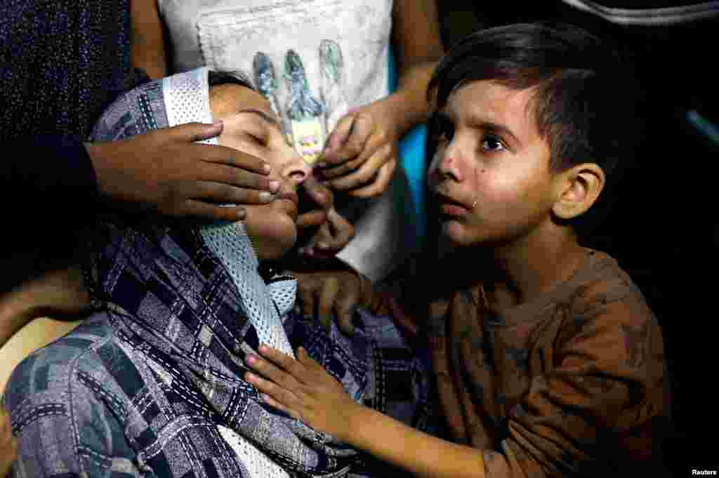 A Palestinian child cries next to his mother after they were rushed into Nasser hospital, following an Israeli strike, n Khan Younis in the southern Gaza Strip.