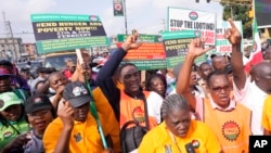 FILE - Labor union members march to protest economic hardship, in Lagos, Nigeria, Feb. 27, 2024. Nigeria's main labor unions agreed on Thursday to a new minimum wage of 70,000 naira ($44) a month after talks with the government.