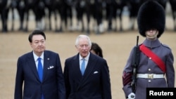 Raja Inggris Charless III menemani Presiden Korea selatan Yoon Suk Yeol dalam kunjungan Yoon ke acara Horse Guards Parade di London, pada 21 November 2023. (Foto: Frank Augstein/Pool via Reuters)