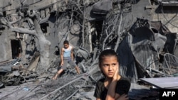 Una niña observa de pie junto a los escombros frente a un edificio que fue alcanzado por un bombardeo israelí en Rafah, en el sur de la Franja de Gaza, el 31 de octubre de 2023.
