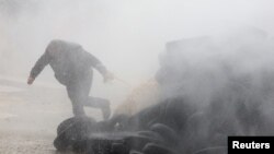 A farmer runs as he is sprayed by a water cannon during a protest of European farmers over price pressures, taxes and green regulation, on the day of an EU Agriculture Ministers meeting in Brussels, Belgium.