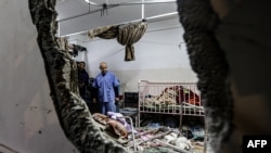 Orang-orang memeriksa kerusakan di sebuah ruangan menyusul pengeboman di Rumah Sakit Nasser di Khan Yunis di Jalur Gaza pada 17 Desember 2023. (Foto: AFP