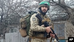 Esta fotografía de 2023 proporcionada por un soldado profesional de 32 años de Medellín, Colombia, que se hace llamar Checho, lo muestra con su equipo de combate en Donbas, al este de Ucrania.