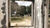 FILE - Children are seen through a broken window on September 30, 2022 in the port city of Palma where fighters affiliated to the Islamic State group attacked months prior. 