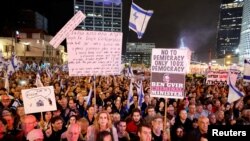 People attend a demonstration as Israeli Prime Minister Benjamin Netanyahu's nationalist coalition government presses on with its judicial overhaul, in Tel Aviv, March 25, 2023.