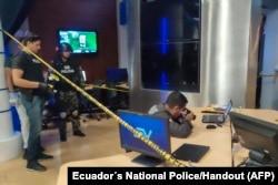 Police officers collect evidence after a device detonated at the Ecuavisa channel premises in Guayaquil, Ecuador, March 20, 2023.