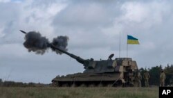 Ukrainian soldiers fire an AS90 during an exercise at a training camp in an undisclosed location in England, March 24, 2023. The second cohort of Ukrainian artillery recruits is finishing the training on the AS90, a 155mm self-propelled gun.