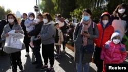 北京儿童医院外排队等候看病的儿童与家长。（2023年11月24日）