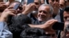 Reformist candidate in Iran's presidential election Masoud Pezeshkian is greeted by his supporters as he arrives to vote at a polling station in Shahr-e-Qods near Tehran, Iran, July 5, 2024. 