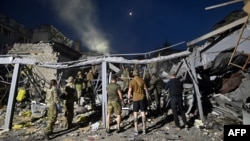 Rescuers and volunteers work to rescue people from under the rubble after Russian missile strike hit a restaurant and several houses in Kramatorsk, eastern Ukraine, June 27, 2023.