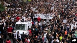 The mother of killed 17-year-old Nahel, at left on truck, gestures during a march for Nahel, June 29, 2023 in Nanterre, outside Paris.